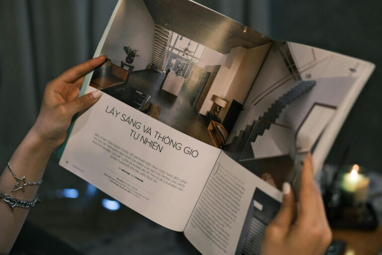 Close-up of hands holding a magazine featuring modern interior design.